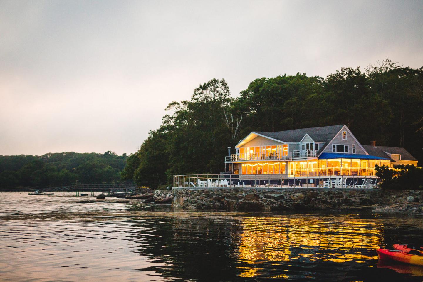 Waterfront wedding venue at dusk with lights on