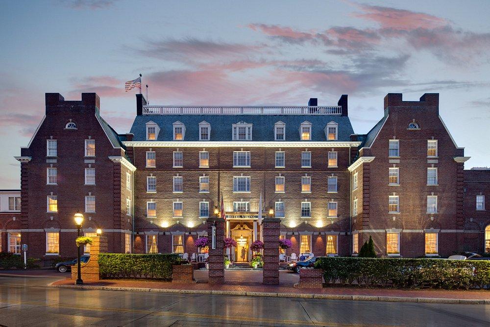 Historic brick hotel at dusk with warm lights and a symmetrical facade.
