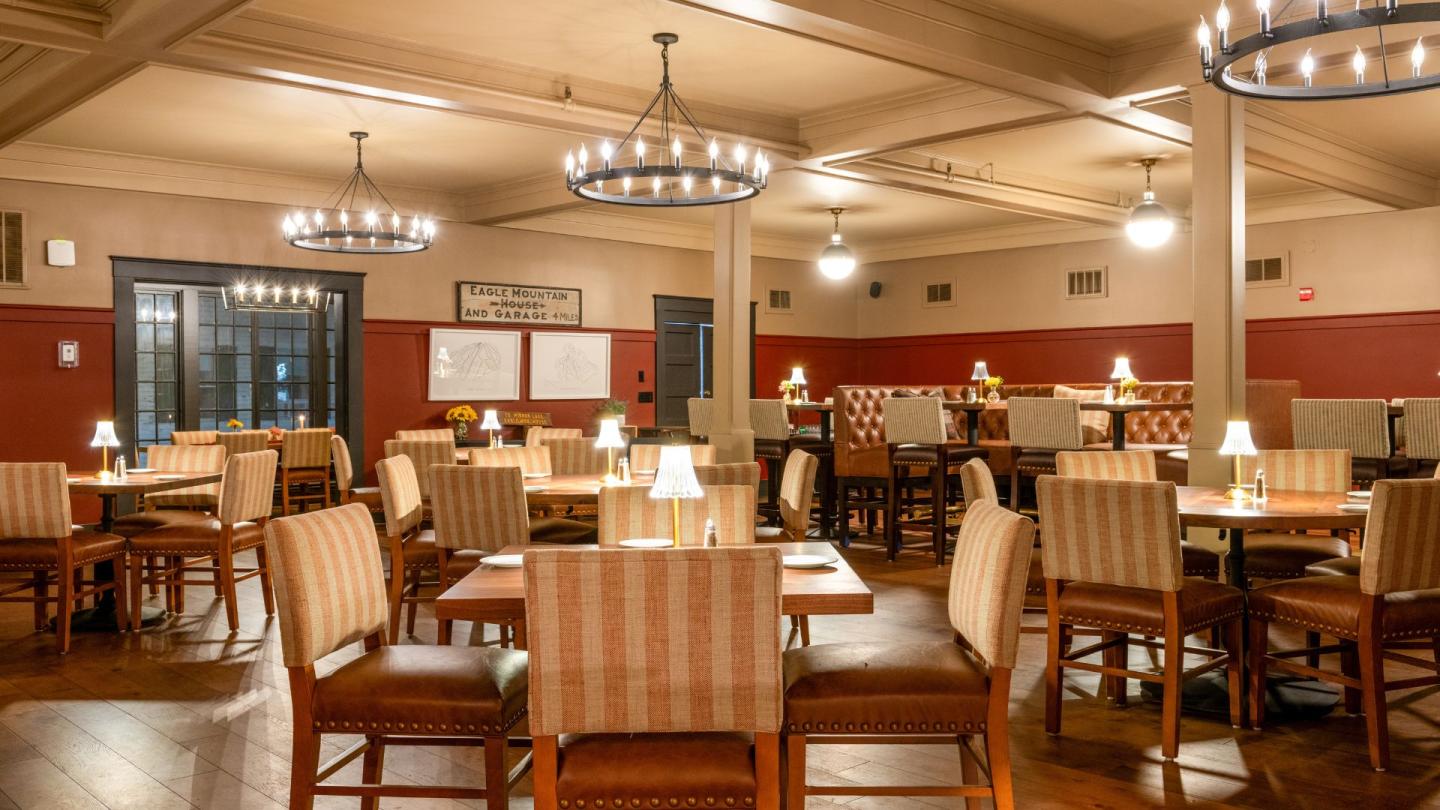 Cozy dining room with tables, chairs, warm lighting, and red walls.