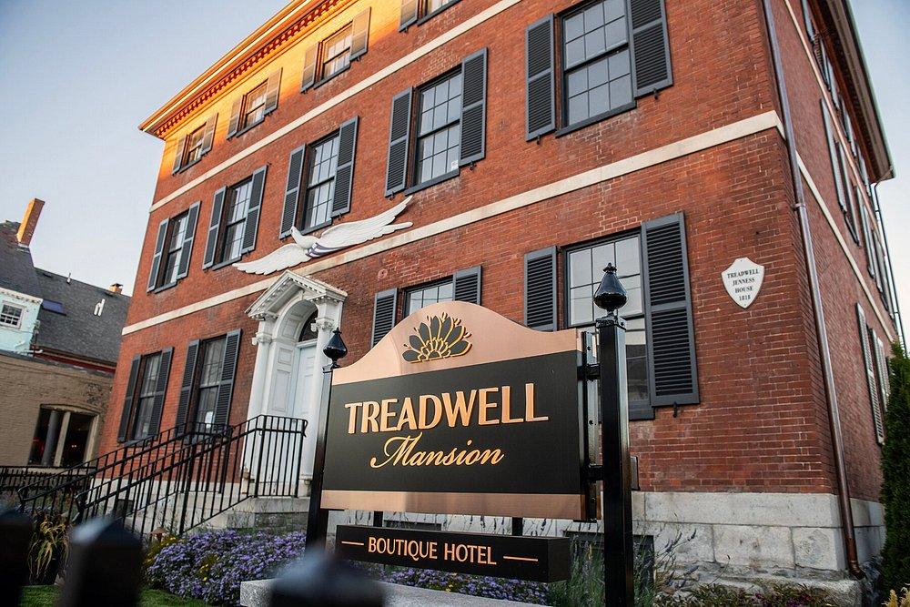 Historic brick building with a "Treadwell Mansion" hotel sign in front.