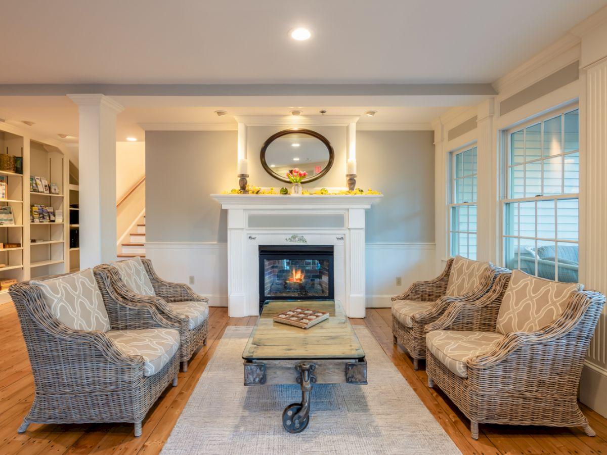 Cozy living room with wicker chairs, fireplace, and mirror.