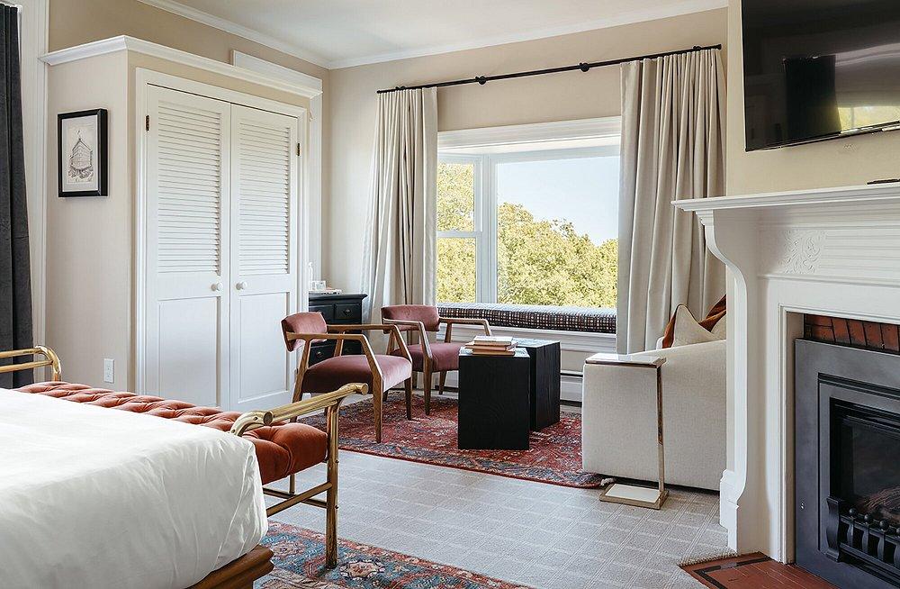 Tasteful room with a bed, fireplace, and a large window view.