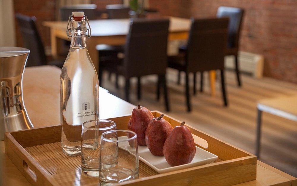 Tray with pears, glasses, and a water bottle on a table in a cozy dining area.