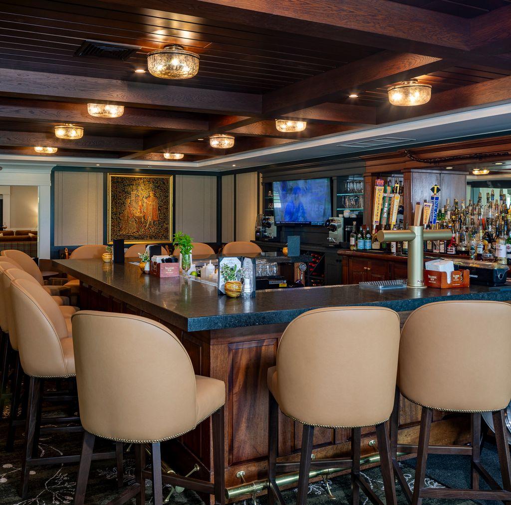 Bar area with beige stools, wood accents, and dim lighting.