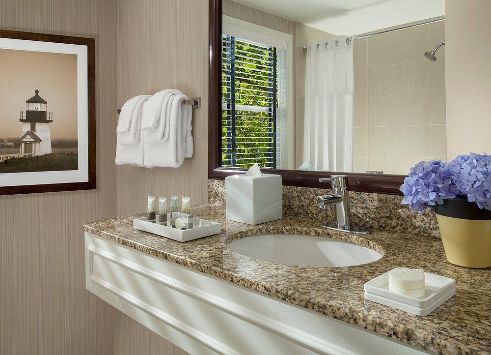 Elegant bathroom with granite countertop, sink, and purple flowers.
