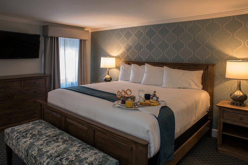 King-size bed in a cozy hotel room with breakfast tray.