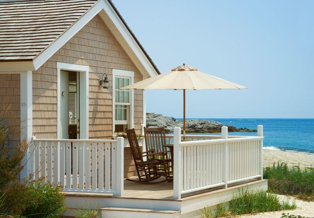 Cozy beach cottage with deck, rocking chairs, and ocean view.