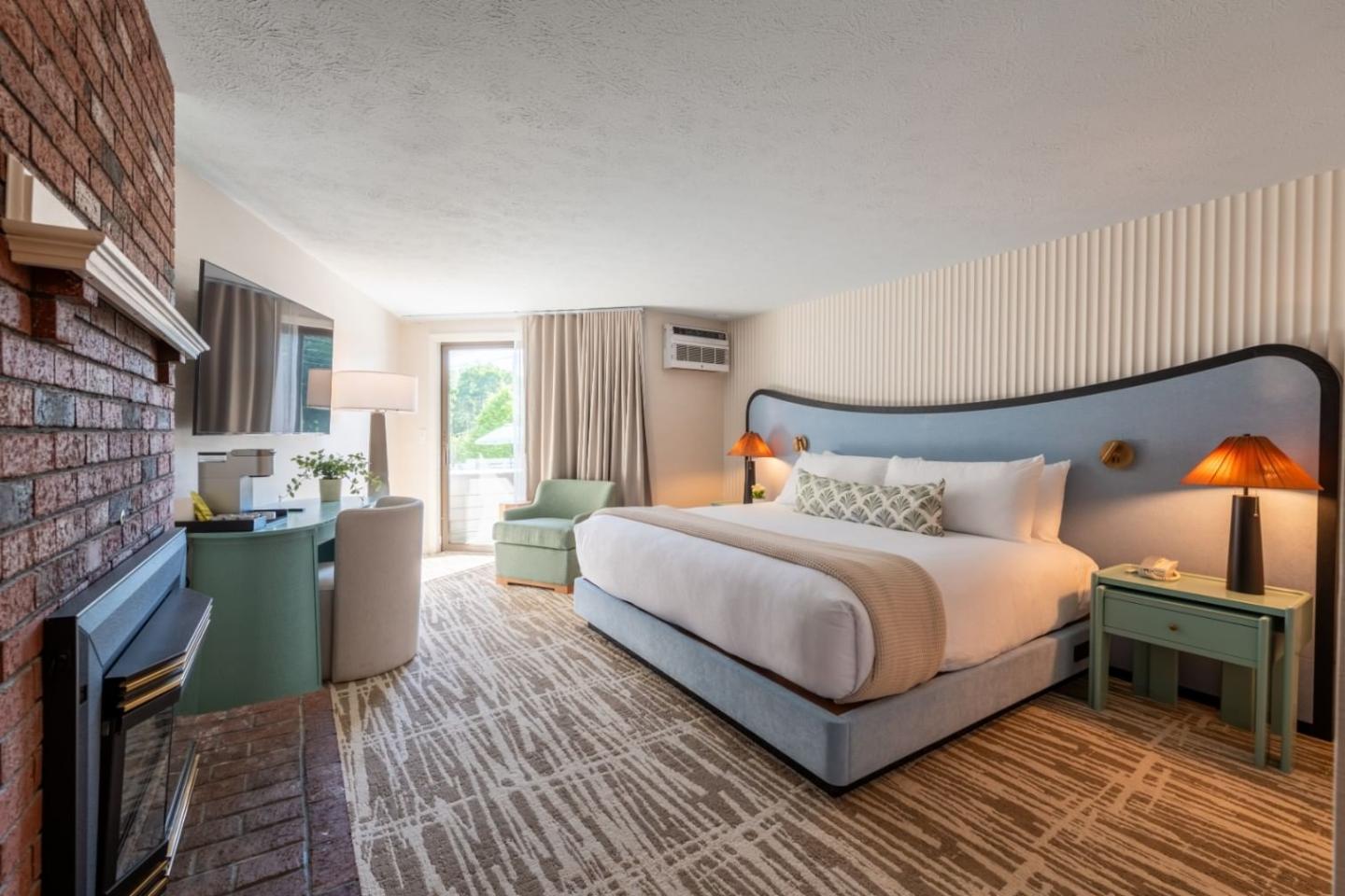 Elegant hotel room with a king bed, seating area, and large window.
