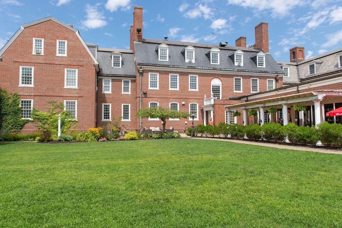 Large brick building with a manicured lawn and blue sky.