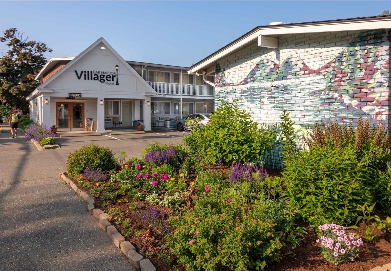 Motel with colorful flower garden and mural in the morning light.