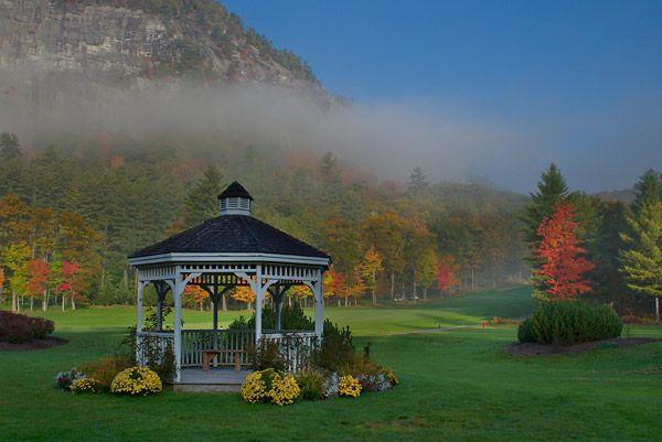 Gazebo on a misty autumn morning, surrounded by colorful trees.