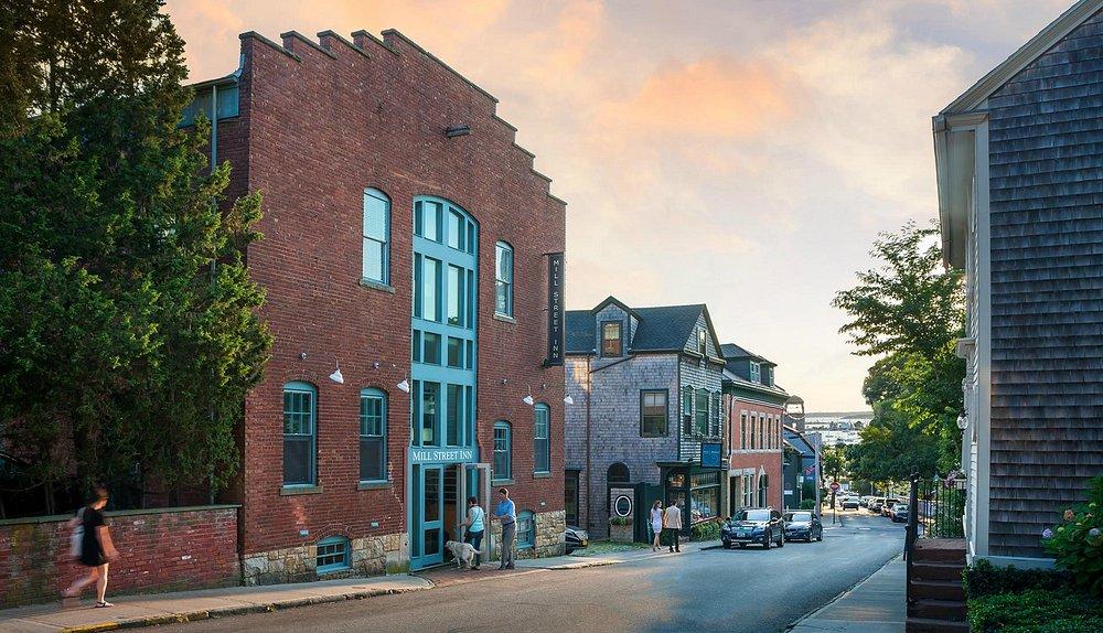 Street view with brick buildings and trees under a sunset sky.