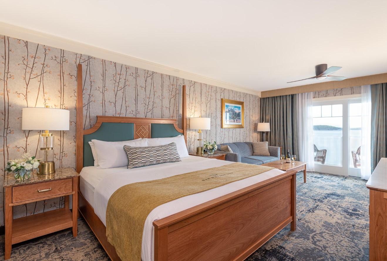 Cozy hotel room with a large bed, soft lighting, and balcony access.