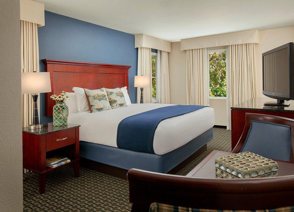 Elegant hotel room with blue accents and large bed.