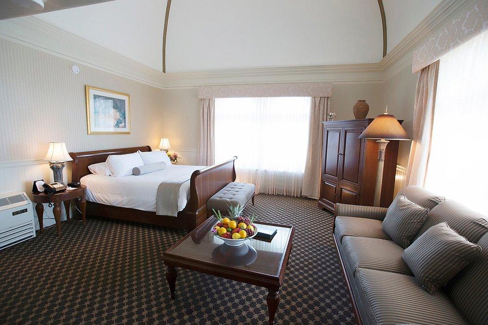 Spacious hotel room with a bed, sofa, and coffee table.