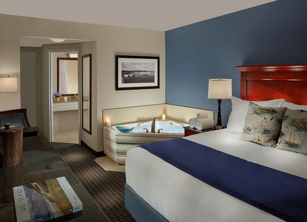 Comfortable hotel room with a bed, sofa, and a jacuzzi near the bathroom.