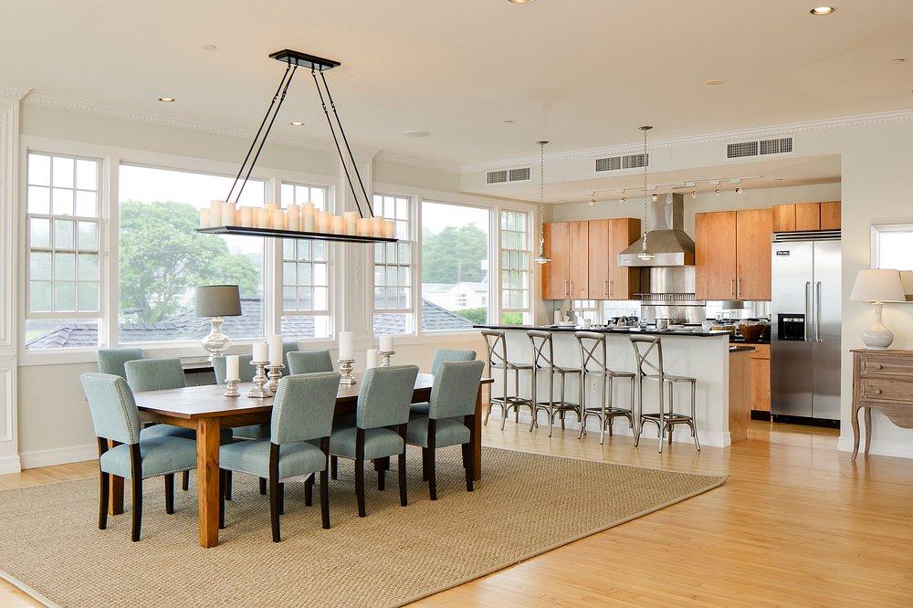 Open-plan kitchen and dining area with light wood and soft blue accents.