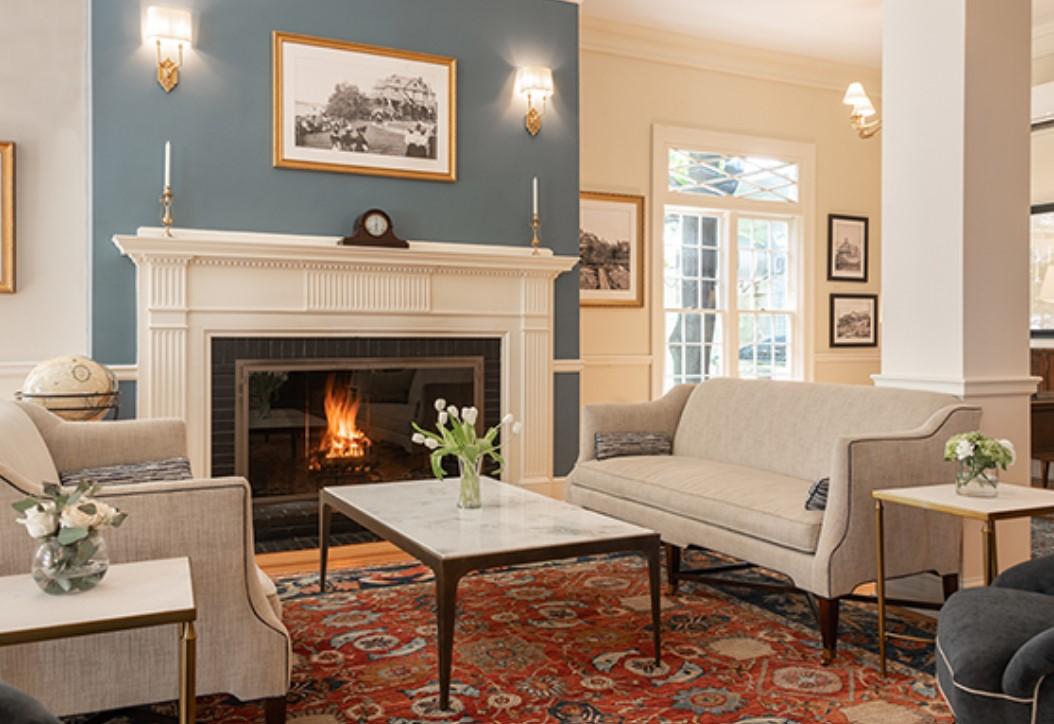 Cozy living room with fireplace, sofas, and floral decor.