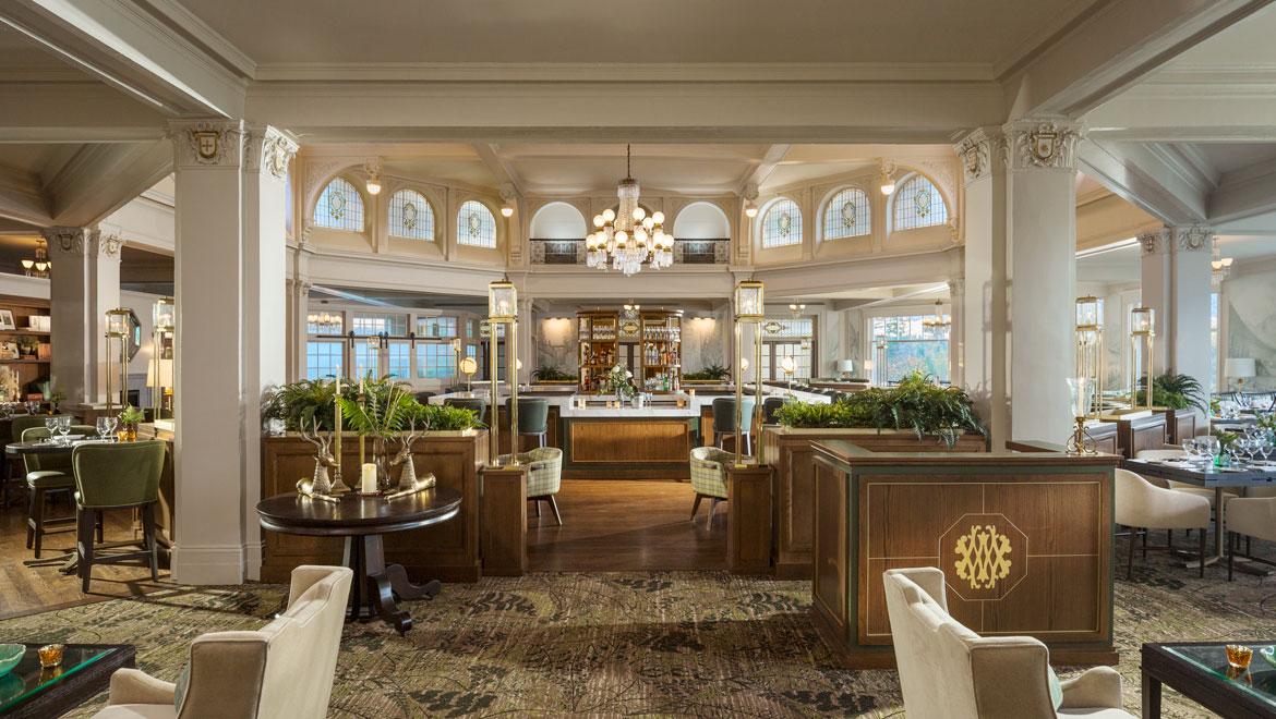 Elegant restaurant interior with chandelier, soft lighting, and seating areas.