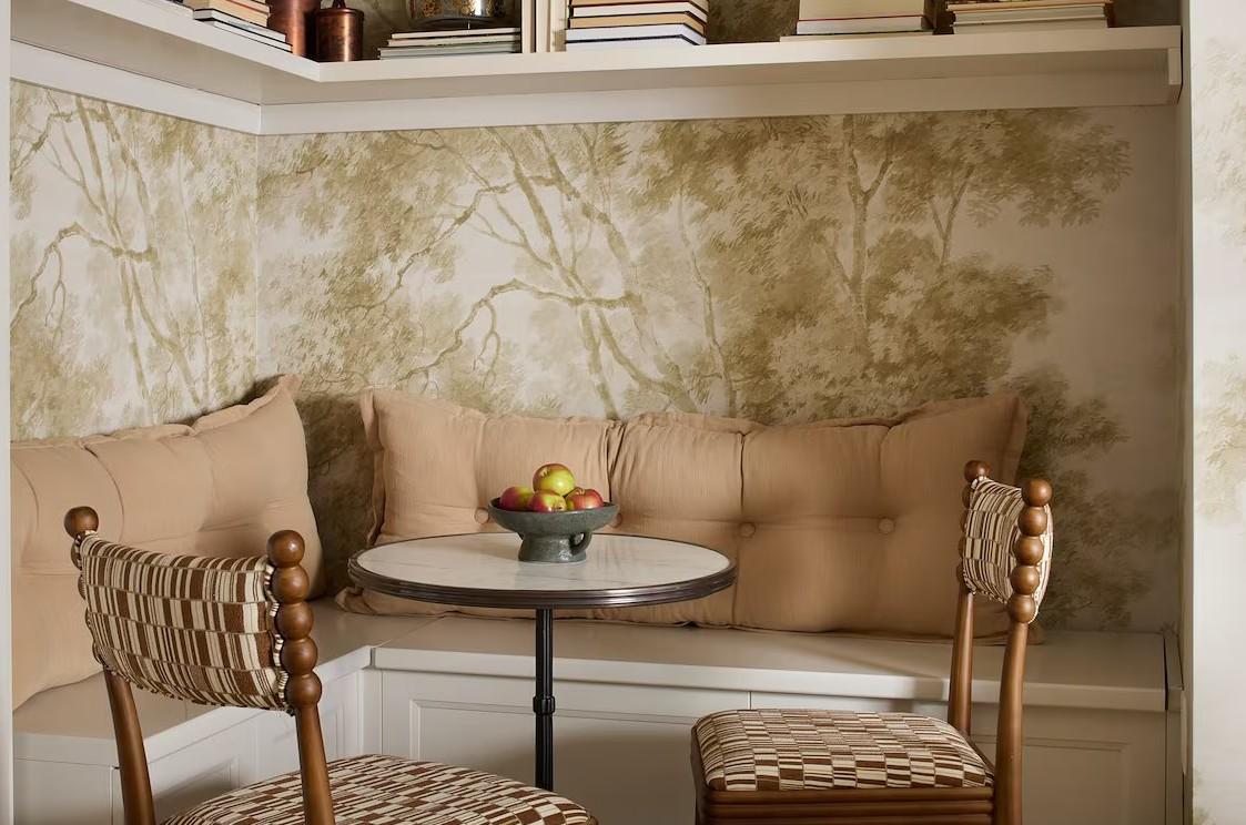 Cozy nook with round table, chairs, and cushioned bench, neutral tones.