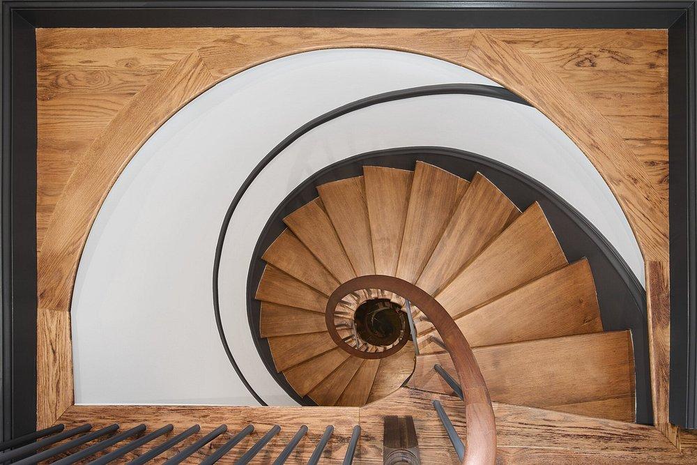 Spiral staircase with wooden steps from above.
