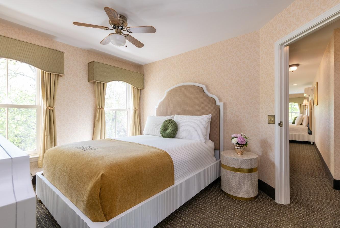 Cozy bedroom with a single bed, gold accents, and soft lighting.