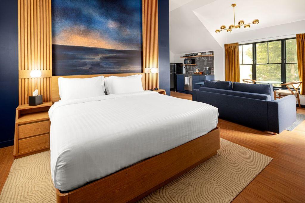 Spacious bedroom with a large bed, cozy seating area, and warm lighting.