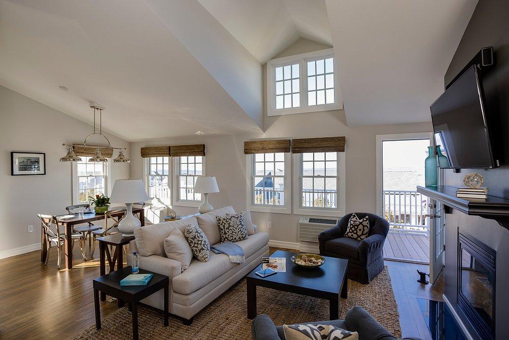 Spacious living room with large windows, sofas, and a fireplace.