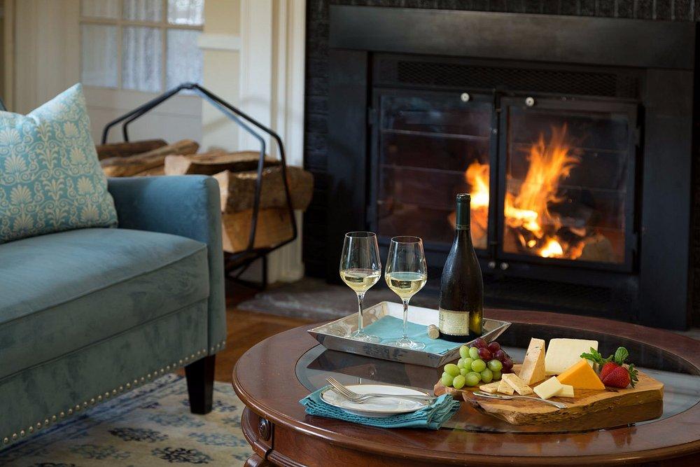 Cozy living room with a fireplace, wine, and cheese platter.