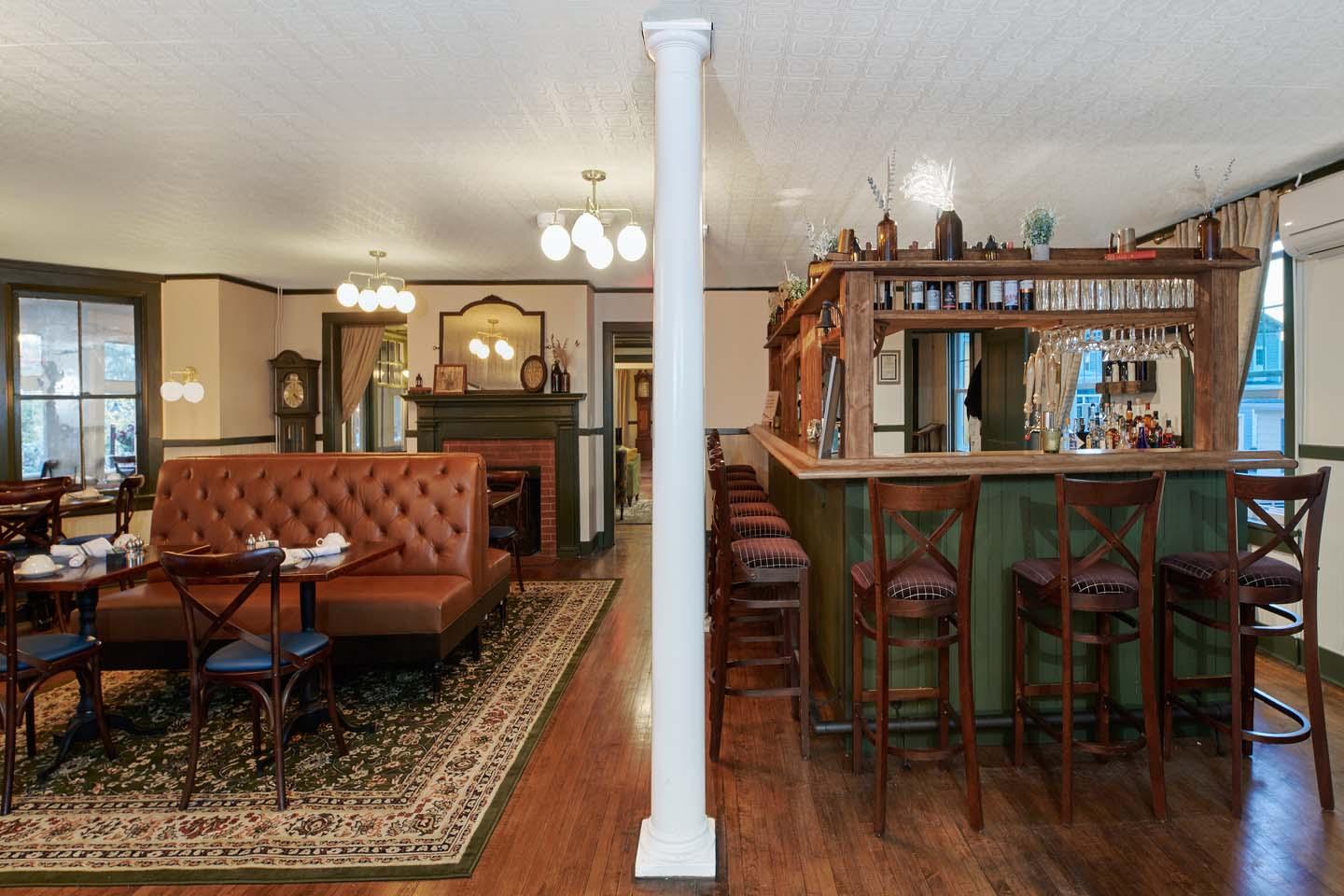 Cozy restaurant interior with brown seating and a wooden bar.