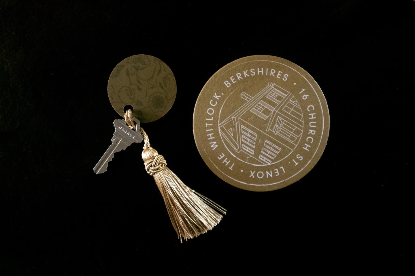 Key with tassel and a round coaster on a dark background.