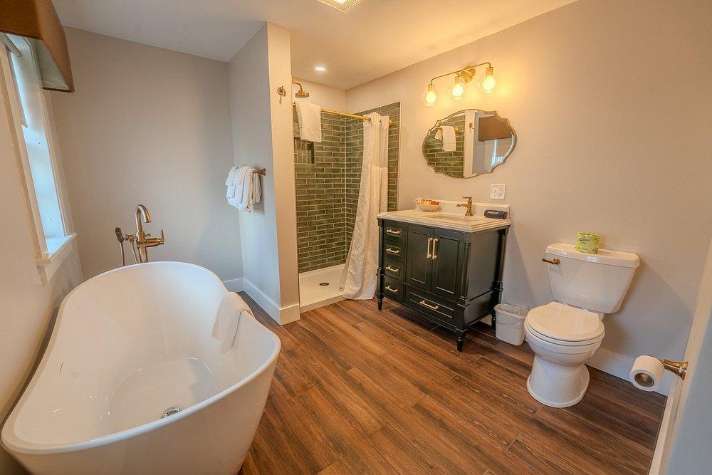 Luxurious bathroom with a freestanding tub, wood floor, and elegant vanity.