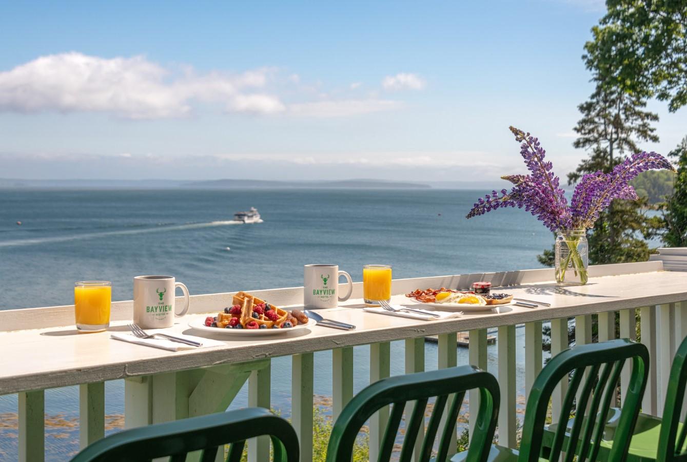 Breakfast on a balcony overlooking the sea with a distant boat.