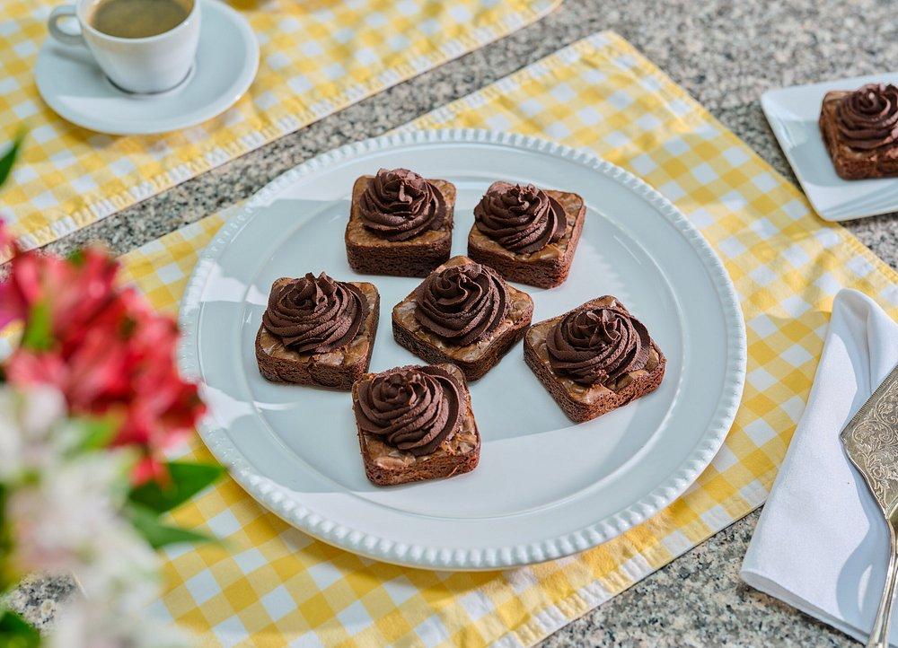 Chocolate cupcakes on a white plate, yellow checkered tablecloth.