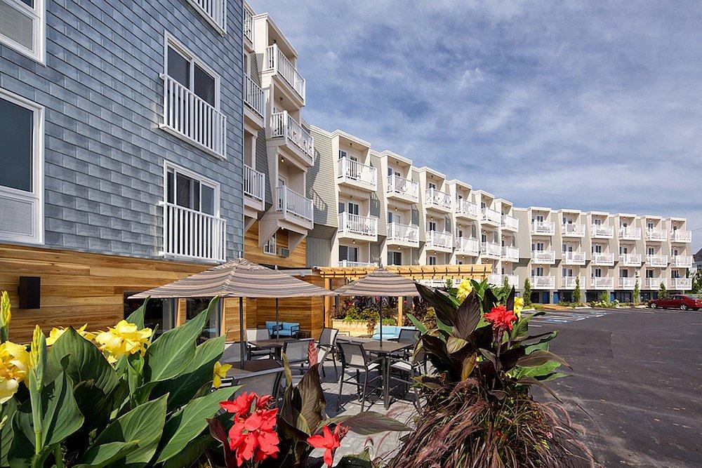 Modern apartment complex with outdoor seating and colorful flowers.