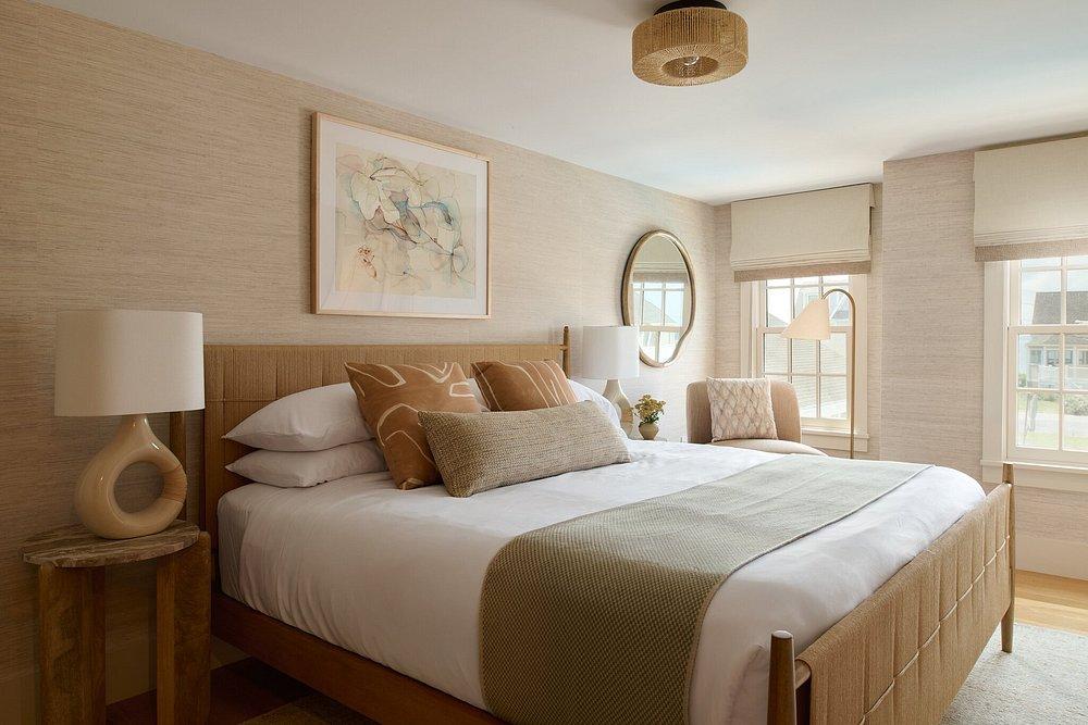 Cozy bedroom with a large bed, neutral colors, and soft natural light.