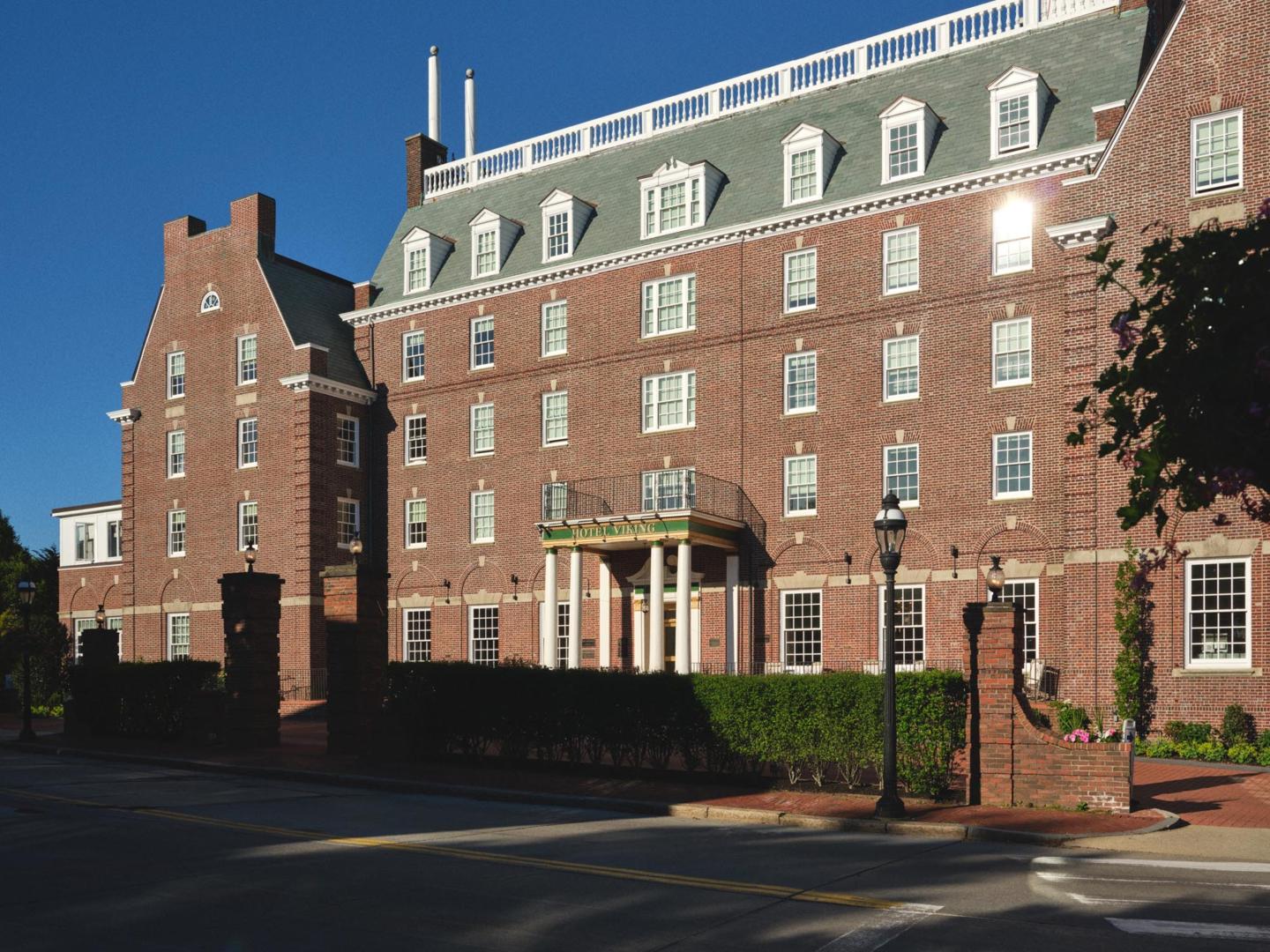 Brick Georgian-style hotel building with white dormer windows and entrance canopy.
