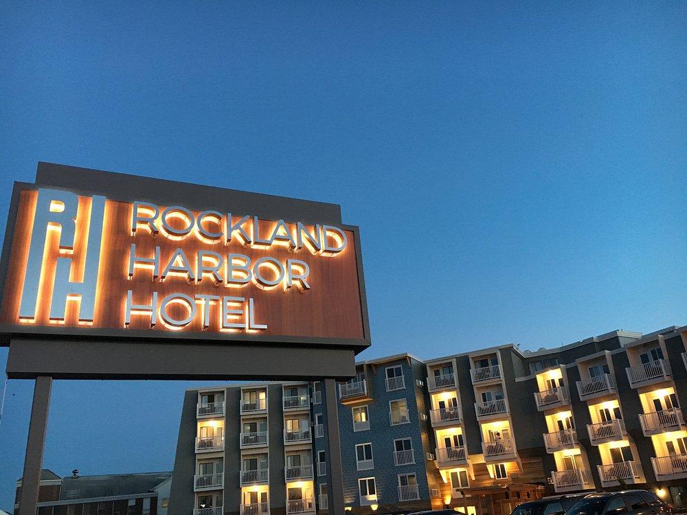 Rockland Harbor Hotel sign at dusk with lit windows in the background.
