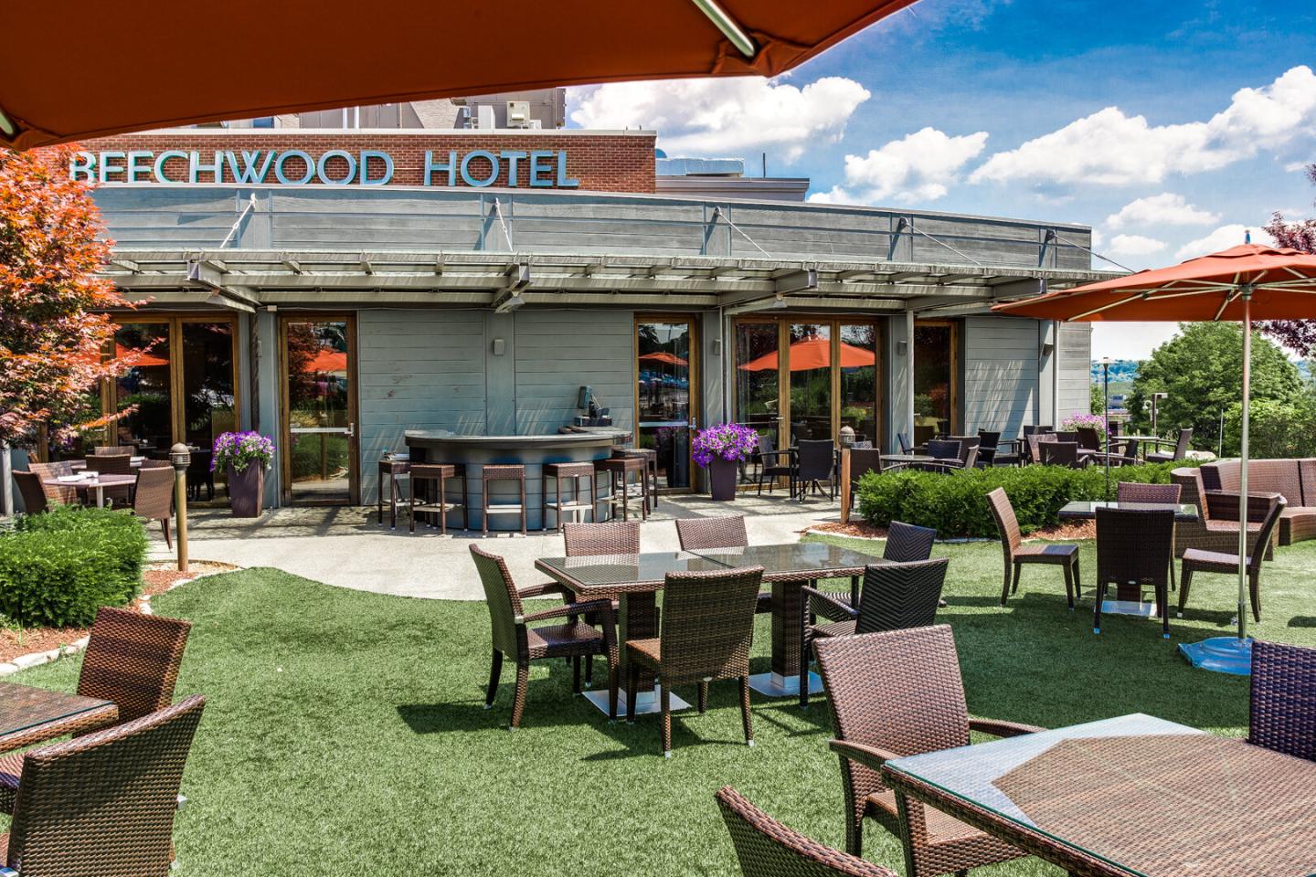Outdoor patio with tables, chairs, and umbrellas at a hotel.
