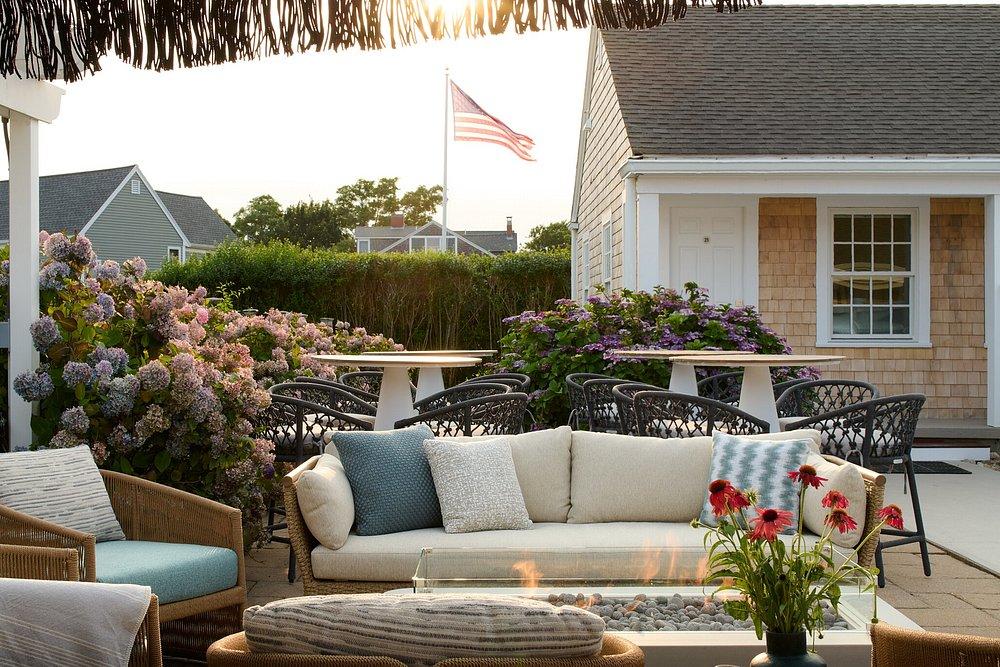Outdoor patio with sofas, flowers, and distant American flag.