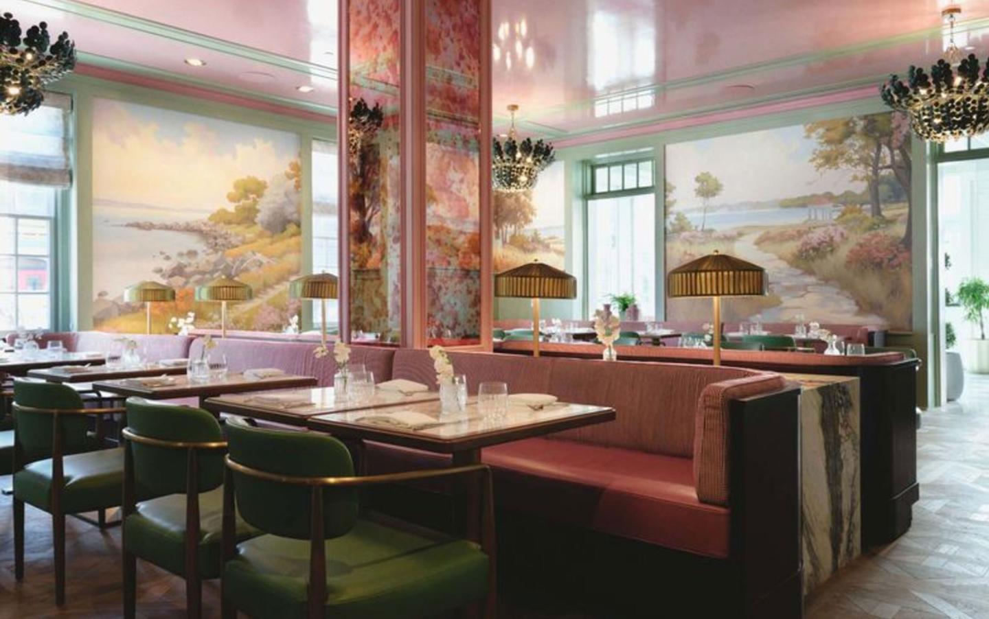 Elegant restaurant interior with pink booths, dark wood tables, and painted landscape murals.