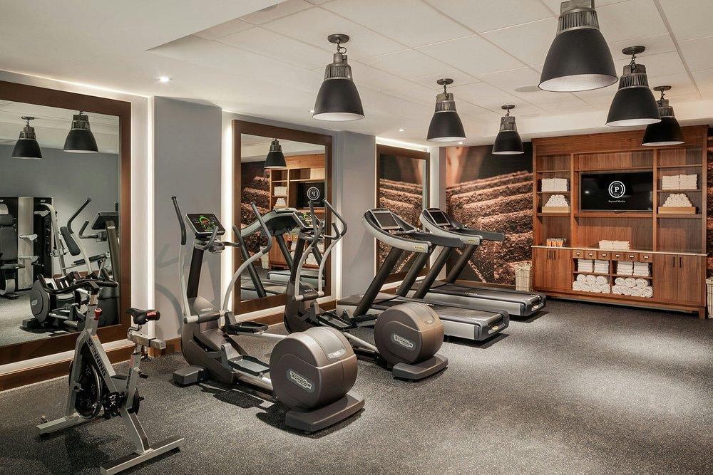 Luxurious home gym with treadmills, elliptical, and a stationary bike.
