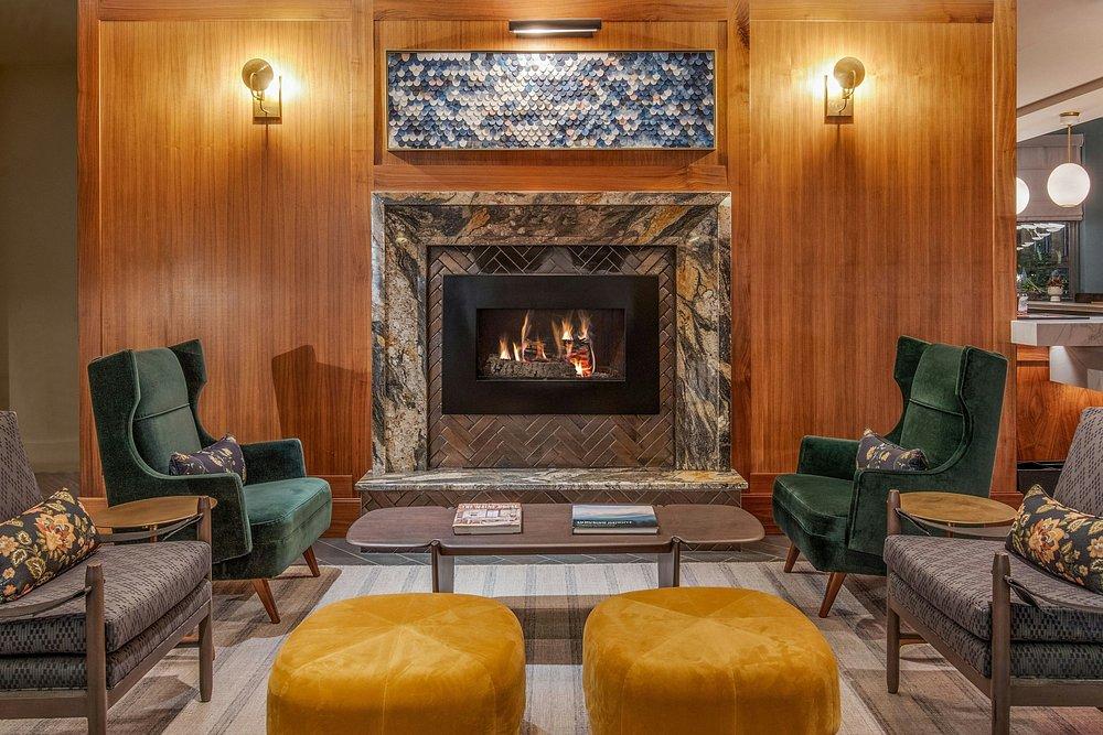 Cozy lounge with armchairs, sofas, and a fireplace.