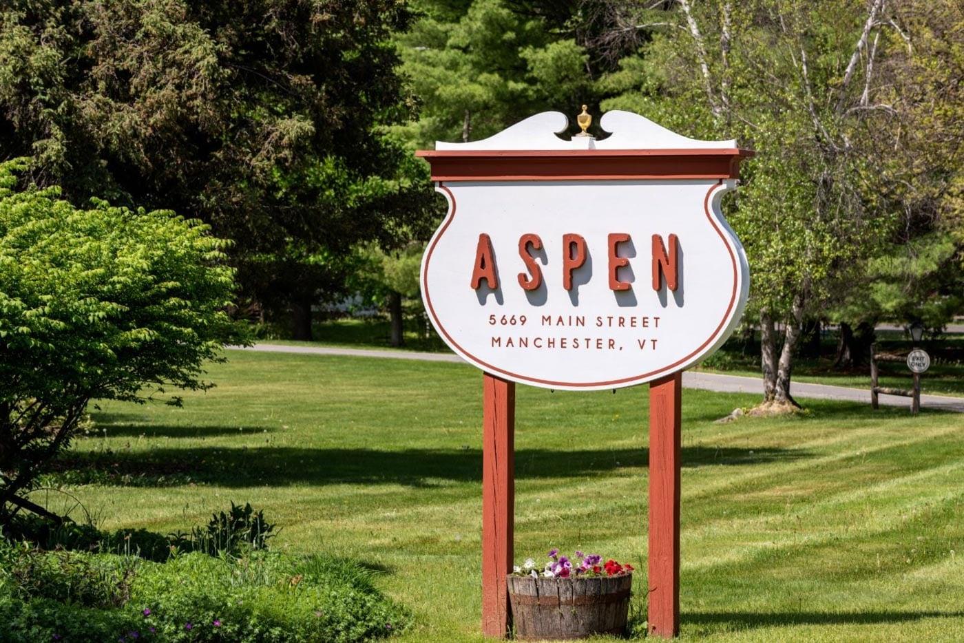 Aspen park sign on a lawn with flowers and trees