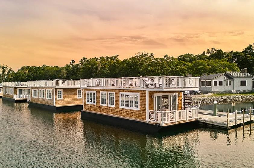 Wooden waterfront restaurant with outdoor deck at sunset.