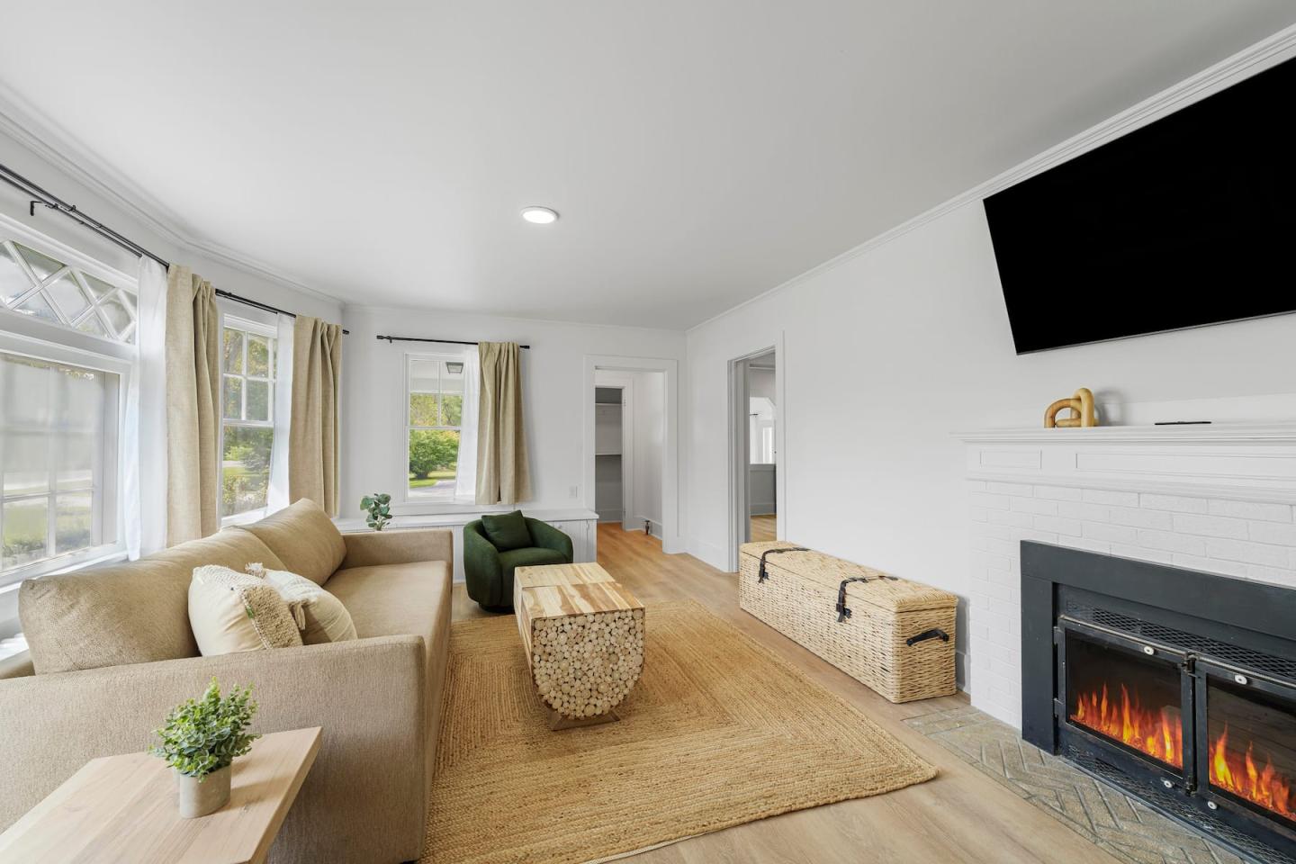 Bright living room with beige sofas, fireplace, and wall-mounted TV.