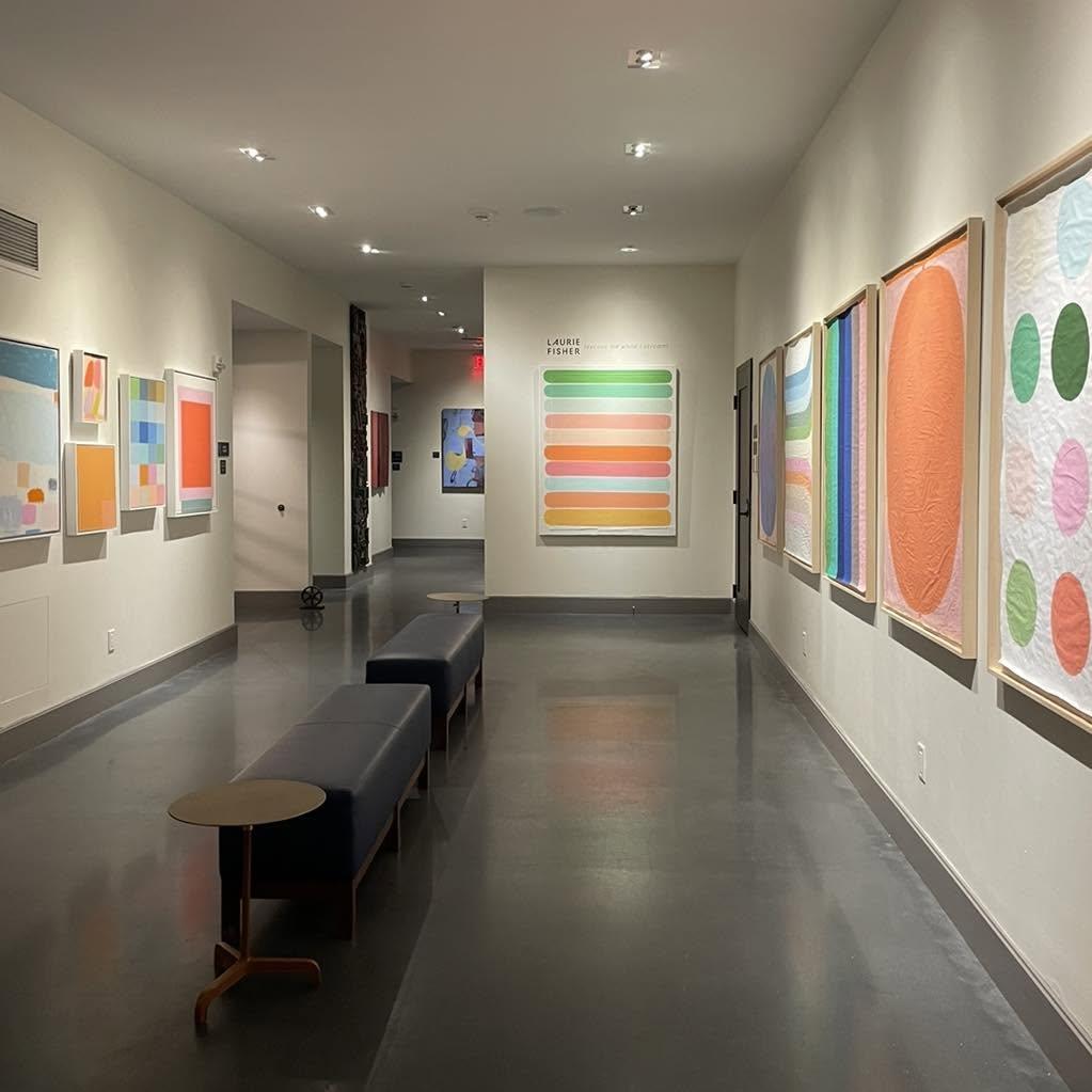 Modern gallery hallway with colorful abstract artworks and benches.Art Gallery