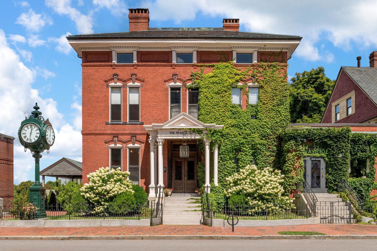 Red-brick Victorian house with ivy-covered facade and landscaped garden