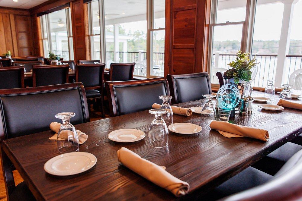 Elegant dining room with a set wooden table, leather chairs, and large windows.
