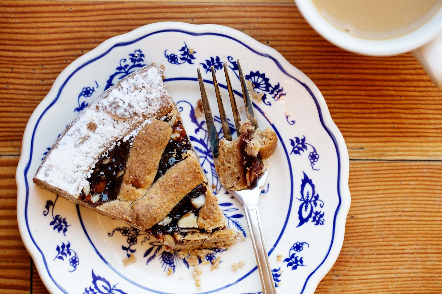 Linzertorte with powdered sugar on white and blue plate